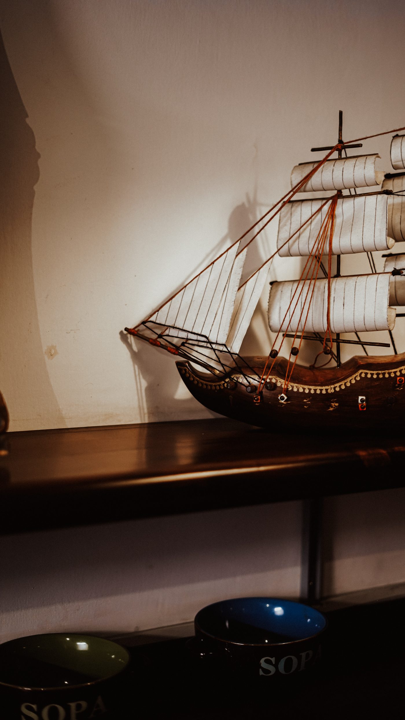 Model sailing ship above soup bowls
